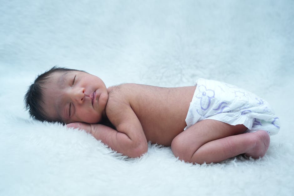 A serene newborn baby sleeping on a soft white blanket, capturing innocence and tranquility.