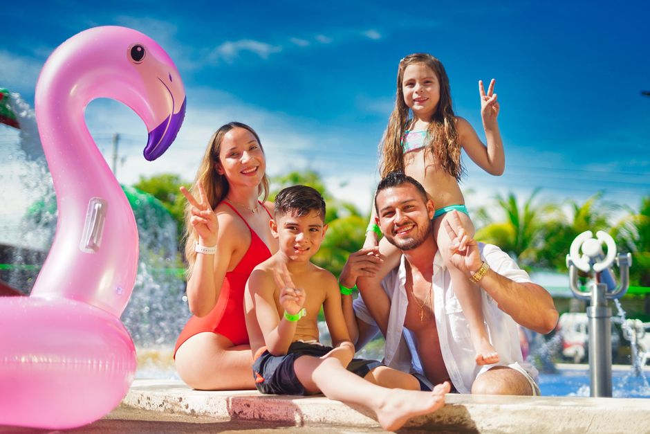 Family enjoying a sunny day by the pool with a pink flamingo float, creating joyful memories.