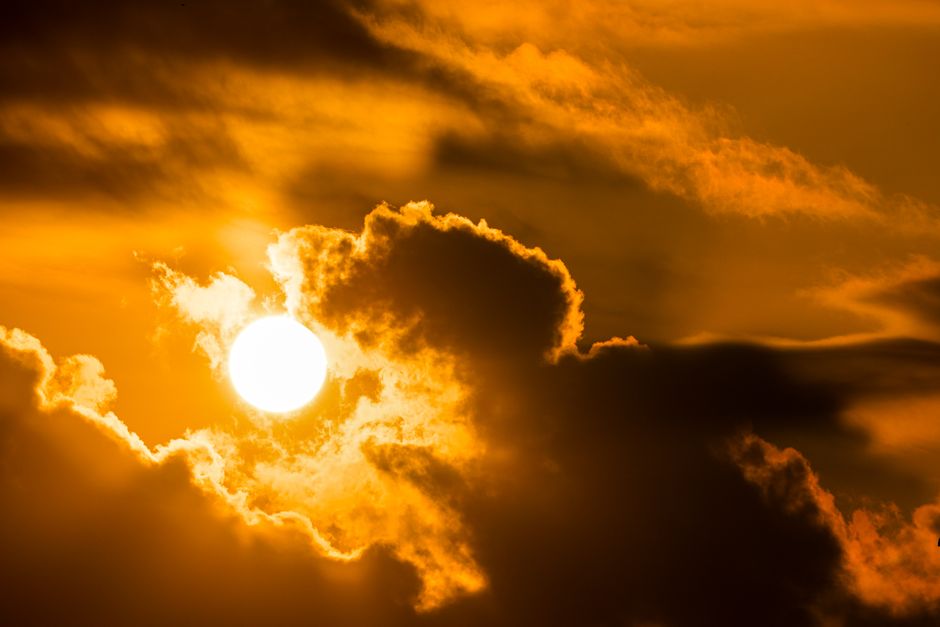 Stunning sunset with vibrant orange clouds and dramatic lighting, perfect for nature themes.