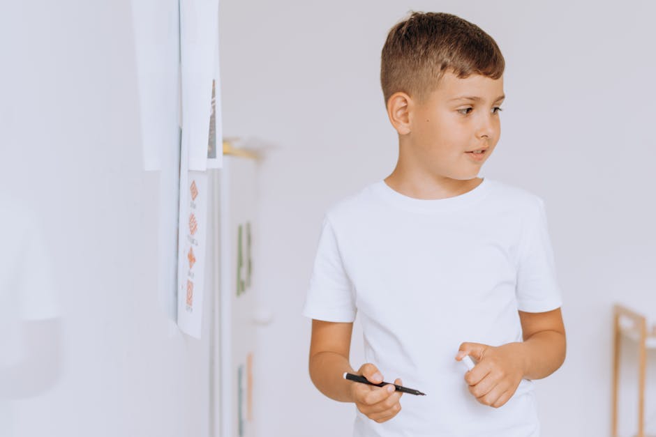 A young boy studying with a pen in a classroom, emphasizing learning and education.