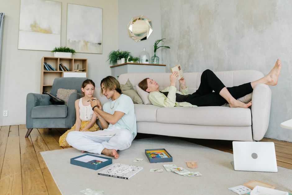 A family enjoys a relaxing day in a cozy living room, reading and bonding together.