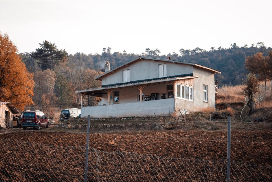 A rustic farmhouse set in the autumn countryside, showcasing a rural lifestyle.