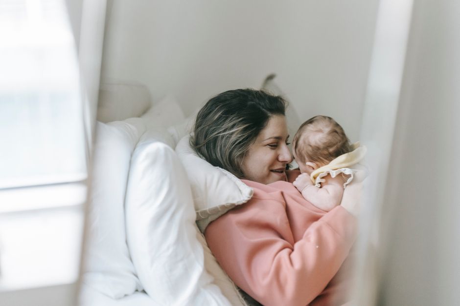 A tender moment shared between mother and baby, showcasing love and togetherness indoors.