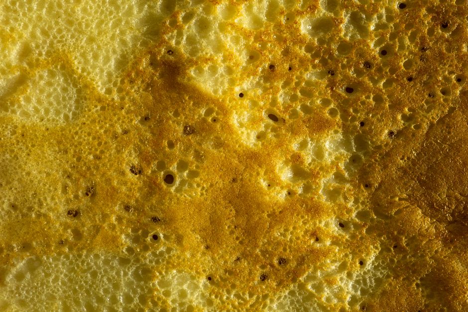 High-resolution close-up of a golden honeycomb-like structure with intricate textures and patterns.
