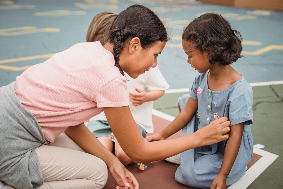 Young girls enjoy playtime outdoors, sharing friendship and creativity.