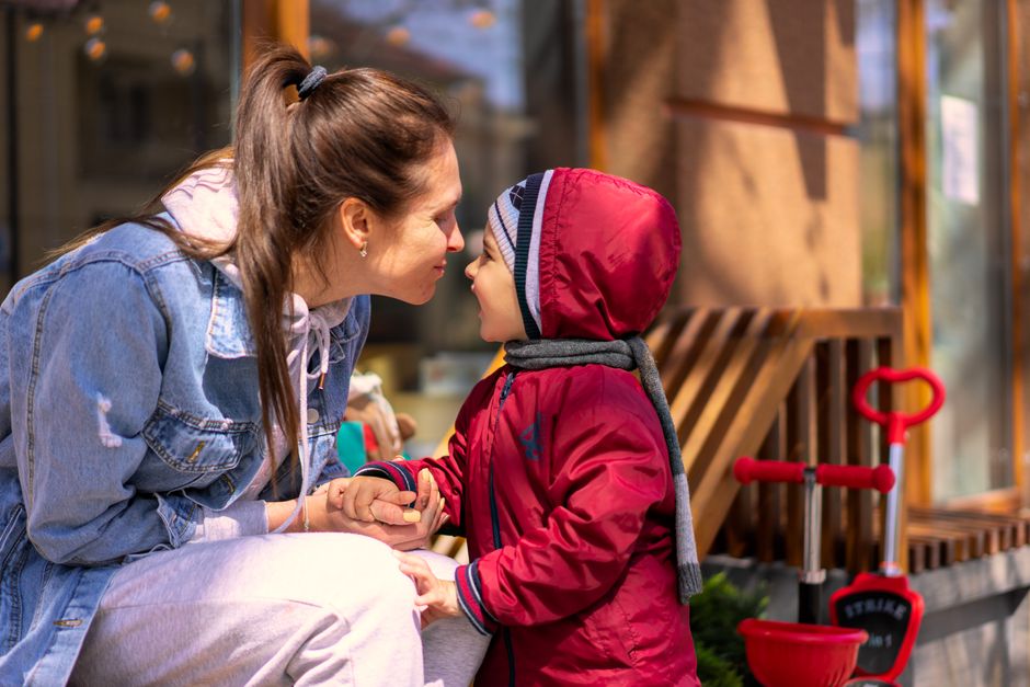 A loving mother and her son enjoy a playful moment outdoors, capturing warmth and joy.