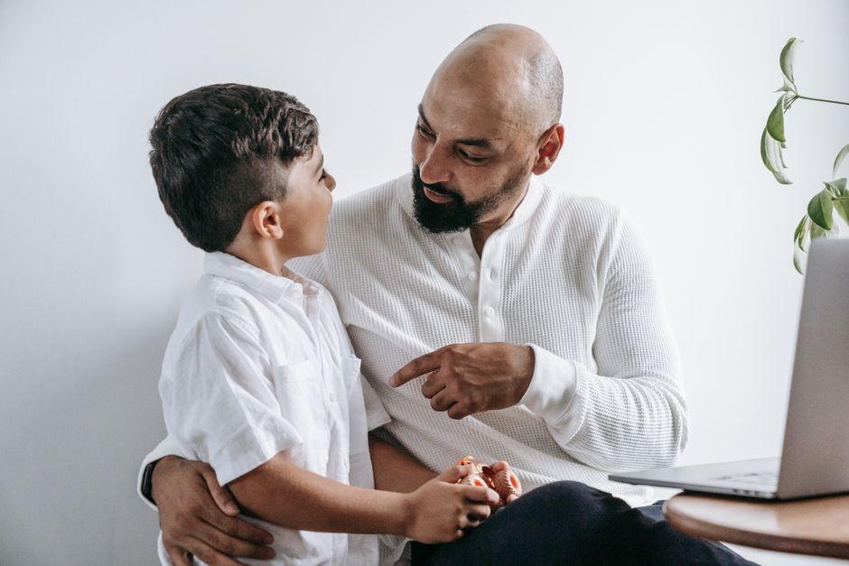 A touching scene of a father and son engaging in a deep conversation at home.