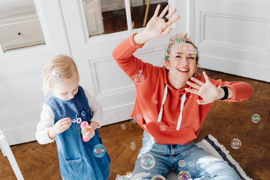 Joyful scene of a woman and child playing with bubbles indoors, capturing laughter and fun.